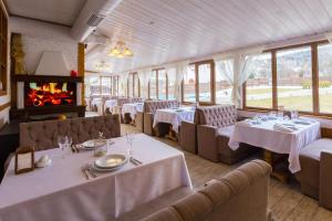 亚列姆切Hotel&Restaurant Premium Club的一间带桌椅和壁炉的用餐室