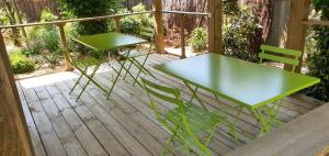 奥瑟戈尔Villa Uhaïna Hossegor的木甲板上配有两张绿色的桌椅