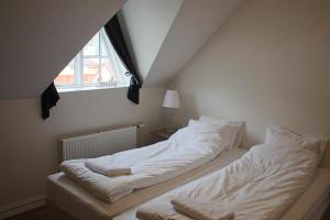 伊萨菲尔德月亮小屋宾馆的一间卧室配有一张带白色床单的床和一扇窗户。