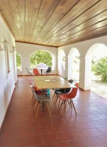 塞卡尔Portela Guesthouse的一间设有木制天花板和桌椅的用餐室
