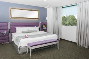 托卢卡托卢卡皇冠假日酒店 - 兰开斯特的一间卧室设有一张紫色墙壁的大床