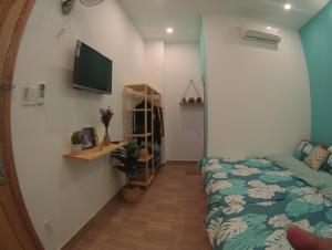 头顿HD House Homestay Vũng Tàu的一间卧室配有一张床,墙上配有电视