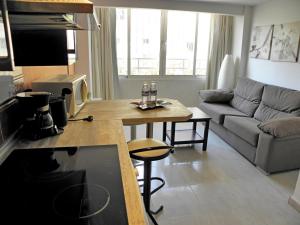 贝纳尔马德纳JSM公寓的厨房以及带桌子和沙发的客厅。