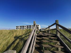 布雷斯肯斯米利阿诺酒店的通往海滩上一座建筑的木楼梯