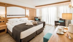 塞尔瓦迪加尔代纳山谷Giardin Boutique Hotel B&B的酒店客房带一张大床和一把椅子
