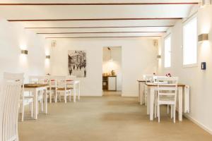 哈伦贝格Hof Hallenberg的用餐室配有白色的桌子和白色的椅子