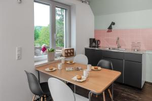 科隆Das Wiesenhaus: Wohnen direkt am Rhein的厨房配有木桌、椅子和水槽