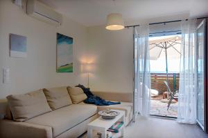 格利法达Ammos Beach House的带沙发和滑动玻璃门的客厅