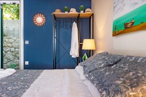格利法达Ammos Beach House的一间卧室设有一张床和蓝色的墙壁