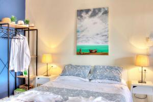 格利法达Ammos Beach House的卧室配有一张床,墙上挂有绘画作品