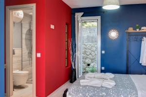 格利法达Ammos Beach House的红色和蓝色的卧室设有一张床和淋浴
