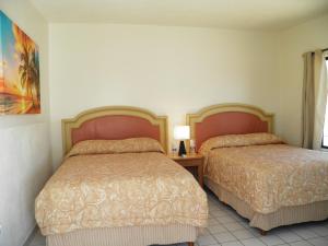 圣费利佩#52 Bungalow Seaside Hotel & Victors RV Park的酒店客房设有两张床和窗户。