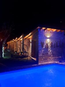 希马拉Palermiti Luxury Rooms的砖砌的建筑,晚上设有游泳池