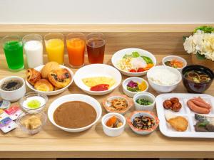 FukuroiKuretake Inn Premium Fukuroi Ekimae的餐桌上有许多不同的食物和饮料