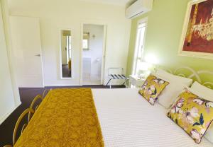蒙特维尔Apple Tree Cottage Montville的卧室配有一张带黄色床单和枕头的大床。