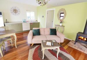蒙特维尔Apple Tree Cottage Montville的客厅配有粉红色的沙发和壁炉