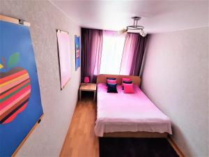 沃罗涅什MEGAPOLIS улица Карла Маркса 76-42的一间卧室配有带粉红色枕头的床和窗户。