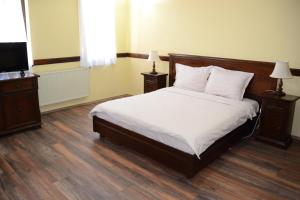Ljubaništa圣瑙姆酒店的一间卧室配有一张床、两盏灯和一台电视。