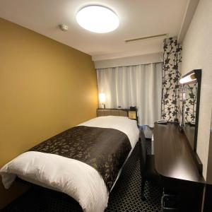 丰桥市APA Hotel Toyohashi-Ekimae的酒店客房设有一张带书桌的床和窗户。