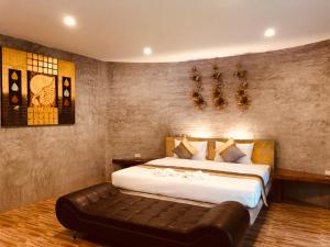Thung SongNao Ta Chuang的一间卧室配有一张大床和一张皮沙发