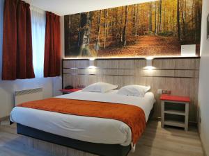 坎特赞Hotel Au Parc des Cigognes的卧室配有一张大床,墙上挂有绘画作品