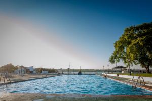 阿尔科斯-德拉弗龙特拉莫林内拉旅馆的一座大游泳池,位于一个有树的公园内