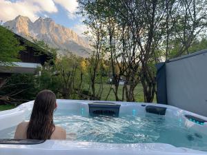 格赖瑙Chalet Zugspitze的坐在热水浴缸中的女人,享有山景