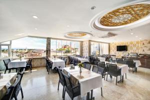 伊斯坦布尔奥雅苏丹酒店的餐厅设有桌椅和大窗户。