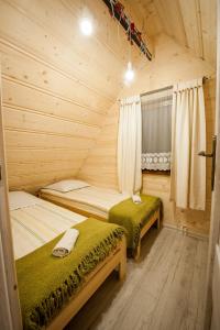 扎科帕内Domki Narciarskie Zakopane的小木屋内一间卧室,配有两张床