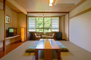 郡山Yutoriro Bandai Atami的客厅设有桌子和大窗户
