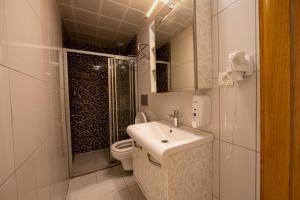 阿奇亚卡MANDALİN AKYAKA的一间带水槽、淋浴和卫生间的浴室