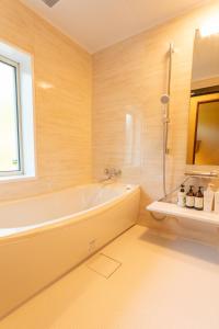 石垣岛YOISAMA Sunset Beach House的带浴缸的浴室和窗户。