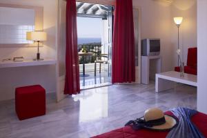 帕蒂迪里奥阿洛尼索斯之阿特瑞芙酒店的客厅配有红色窗帘,享有海景