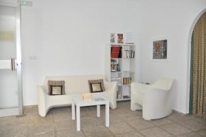 德尼亚奥库洛公寓的客厅配有两把椅子和一张桌子