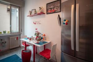 帕尔马Civico 8 B&B - Appartamento的厨房配有桌子和冰箱