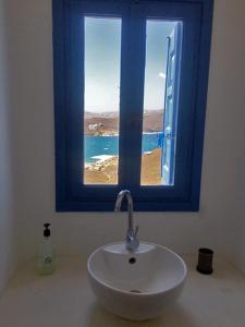 法蒂亚Ftelia Panoramic Sea View Villa Aias的一间带水槽和蓝色窗户的浴室