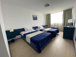 维纳斯Hotel Venus的酒店客房设有两张床和电视。