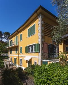 卡麦奥雷Villa Borgovecchio B&B的黄色建筑,上面有绿色百叶窗