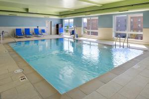 埃尔科Holiday Inn Express & Suites - Elko, an IHG Hotel的一座带蓝色椅子的大型游泳池