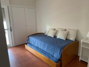 特罗亚Soltroia Housefeelings的一间卧室配有一张带蓝色床单和枕头的床。