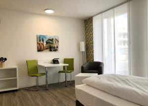 布伦瑞克ADAPT Apartments Braunschweig的酒店客房带一张床、一张桌子和椅子