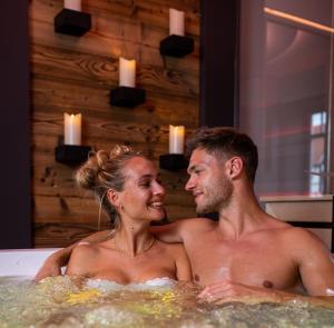 WingerodeSpa Villa Beauty & Wellness Resort的坐在浴缸里的男人和女人