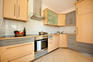 奥拉Villa Trogerhof的厨房配有木制橱柜和炉灶烤箱。