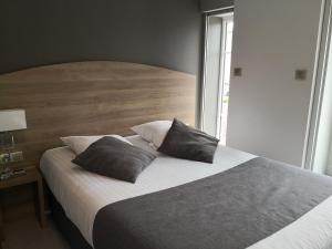 沙拉龙恩河畔沙蒂利翁杜肯梅尔斯酒店的一间卧室配有一张大床和两个枕头