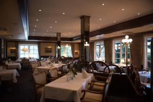 巴特贝德凯萨波塞夫罗曼蒂克酒店的餐厅设有白色的桌椅和窗户。