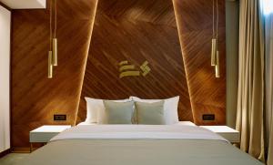 诺维萨德Hotel Pupin Novi Sad的一间卧室配有一张大床和木制床头板