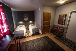 KiviperäIsokenkäisten Klubi - Wilderness Lodge的客房设有两张床和窗户。
