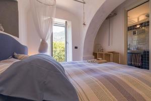 诺利La Casa di Sandra a Noli的一间卧室设有一张床和一个大窗户