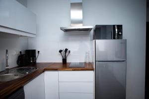 弗农Balcons sur Seine - Vernon Giverny的厨房配有白色橱柜和不锈钢冰箱