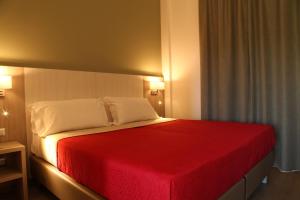 坦皮奥袍沙尼亚保萨尼亚酒店的一间卧室配有一张带红色毯子的床